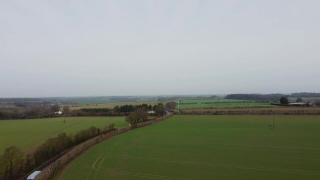 Picturesque drone footage of a country road in Kent. A reveal drone shot of a road.