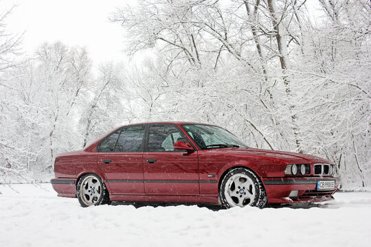 Chernigov, Ukraine - December 21, 2017: Red BMW car on the background of the winter park. Snowy winter and red car. Wonderful winter.