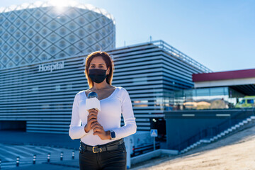 journalist reporting on the covid at the doors of the hospital