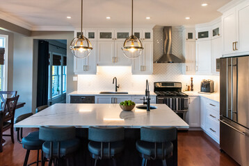 Modern kitchen with white cupboards, dark island and gold accents.