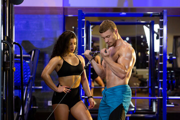 Fototapeta na wymiar Female athlete and male athlete training together in the gym