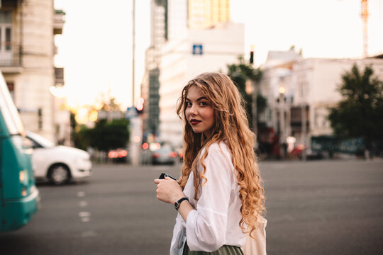 Portrait of serious young woman standing on street in city