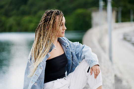 Young woman with blonde braided hair wearing a denim jacket and