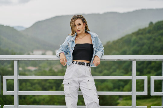 Young woman with blonde braided hair wearing a denim jacket and