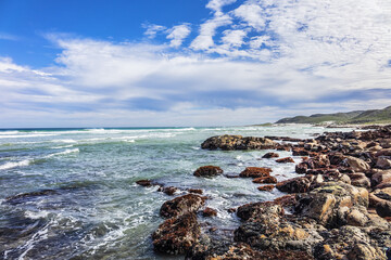 Picturesque view of the rocky shoreline of Atlantic Ocean and Platboom Beach. Platboom Bay is a beautiful beach along coastline nestled in Cape of Good Hope Nature reserve. Cape Town, South Africa.