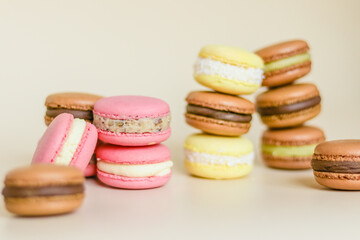 Many multi colored macaroon cakes in stacks on a light background
