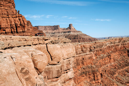 red pickup truck on edge of massive cliff in desert, Moab Utah