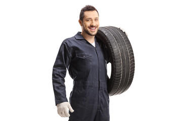 Mechanic holding a car tire and smiling at the camera