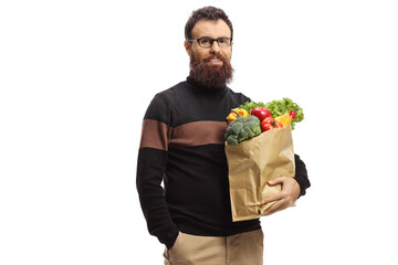 Bearded man with glasses standing with groceries in a paper bag