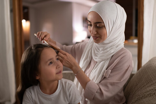 Glad Muslim Mother Doing Hair Of Daughter