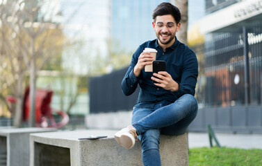 Young man using his mobile phone outdoors.
