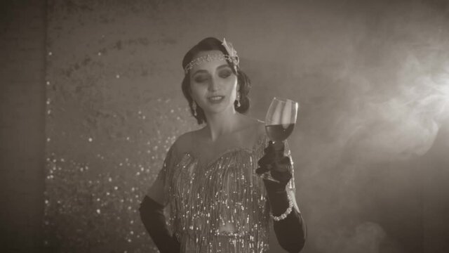 Artwork antique style. Black white film style 20s. Beautiful sexy young retro woman with glass wine in hand smile dancing backdrop sparkling screen smoke flowing. Brunette girl finger wave hairstyle 