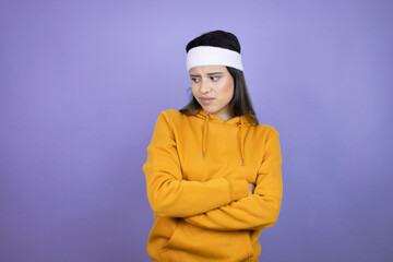 Young latin woman wearing sportswear over purple background Young latin woman wearing sportswear over purple background smiling in love showing heart symbol and shape with hands