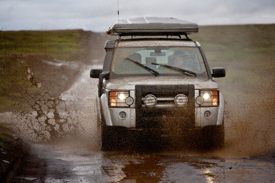 SUV drives on muddy countryside road in Iceland