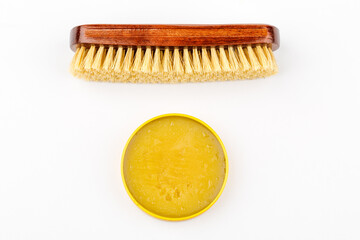 Shoe brush and shoe cream jar are isolated on a white background.