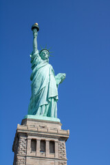 Fototapeta premium Sunny portrait picture of the Statue of Liberty in the harbour of New York