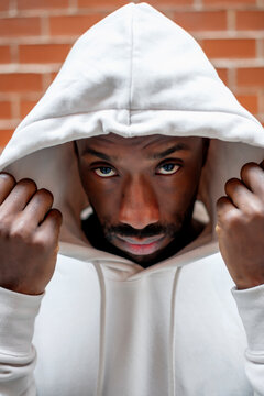 Front shot of African man with serious gesture covering his head with a white hood