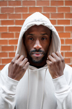 Front shot of African man with serious gesture covering his head with a white hood