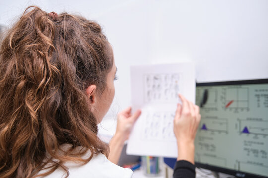 Young female scientist watching at her graphical results in her computer. Laboratory research concept.