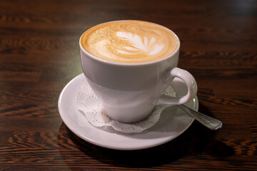 Cup of blck coffee on wooden table in bar.