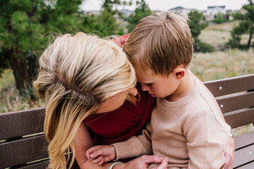 Mother holding and comforting young son outside