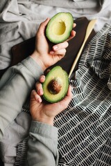 avocado cut in half. avocado in the hands.  fresh avocado cut in half