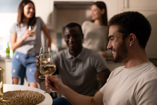 Happy guy enjoying wine during friends party