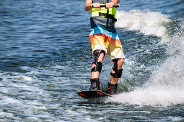 Wakeboard. Athlete's feet on the board on the wave. Special equipment for fixed knees