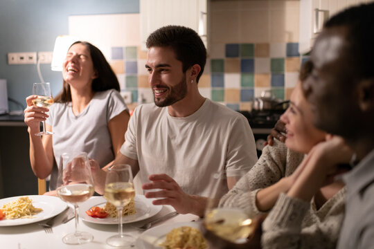 Young man telling stories to diverse friends during party