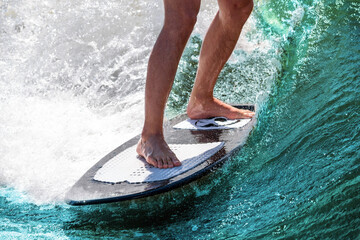 Surfing. Athlete feet on a board on a wave