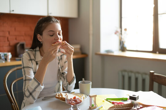 Teenage girl eating breakfast at kitchen table