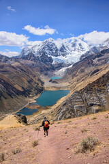 A trekker descending down to Laguna Jahuacocha and the entire Cordillera Huayhuash, Ancash, Peru.