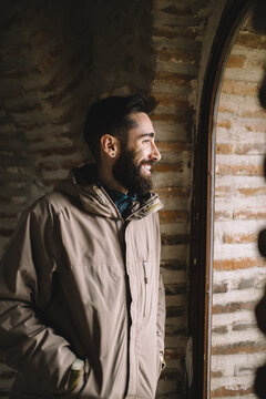Smiling bearded man looking through the window