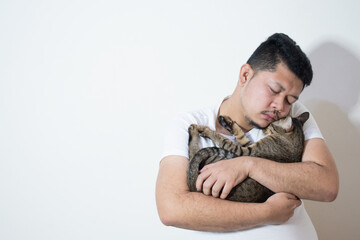 Asian man suffering from depression, he hugs a cute cat to heal his soul