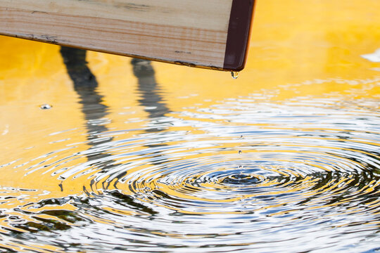 Close-up of water dripping off canoe paddle and splashing in lake - Powered by Adobe