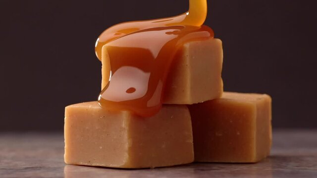 melted caramel sauce flowing on caramel candies closeup