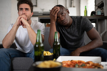 Unhappy diverse friends watching disappointing football match