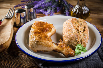 Fried chicken leg with bread roll.