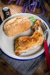 Fried chicken leg with bread roll.