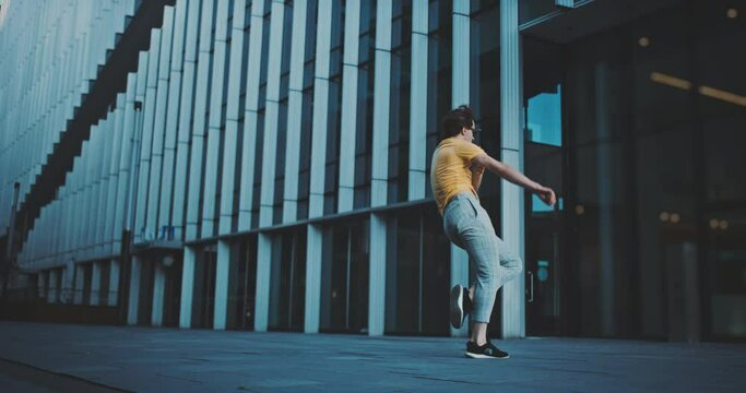 Caucasian male dancer jumping and dancing  in the business district 