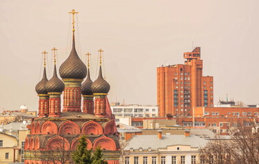 Ancient orthodox church against the background of urban modern architecture