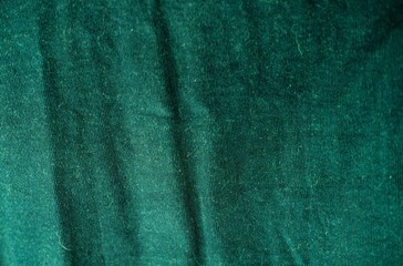 Green velvet surface background. Detailed macro shoot of velveteen velour.