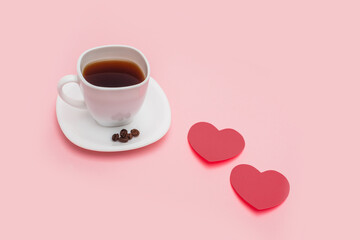 a cup of coffee with hearts made of paper on pink background. Morning mood concept