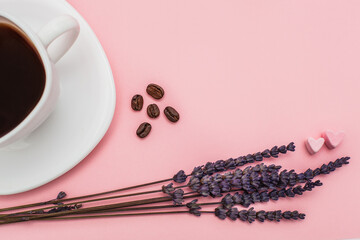 dry Lavender bouquet with a cup of coffee on pink background. Morning mood concept