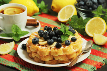 Belgian waffles with blueberry and a cup of tea with lemon