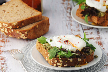 Homemade sandwiches with pesto, green salad and poached eggs