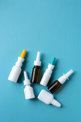 Bottles of nasal spray on blue background, medicine flat lay, treatment for colds