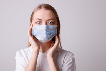 Girl in a medical mask on a gray background