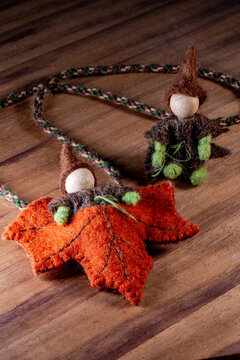 Gnome in an autumn maple leaf and one sitting on the ground.