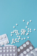 White pills flat lay for blogger medicine content with copy space on blue background